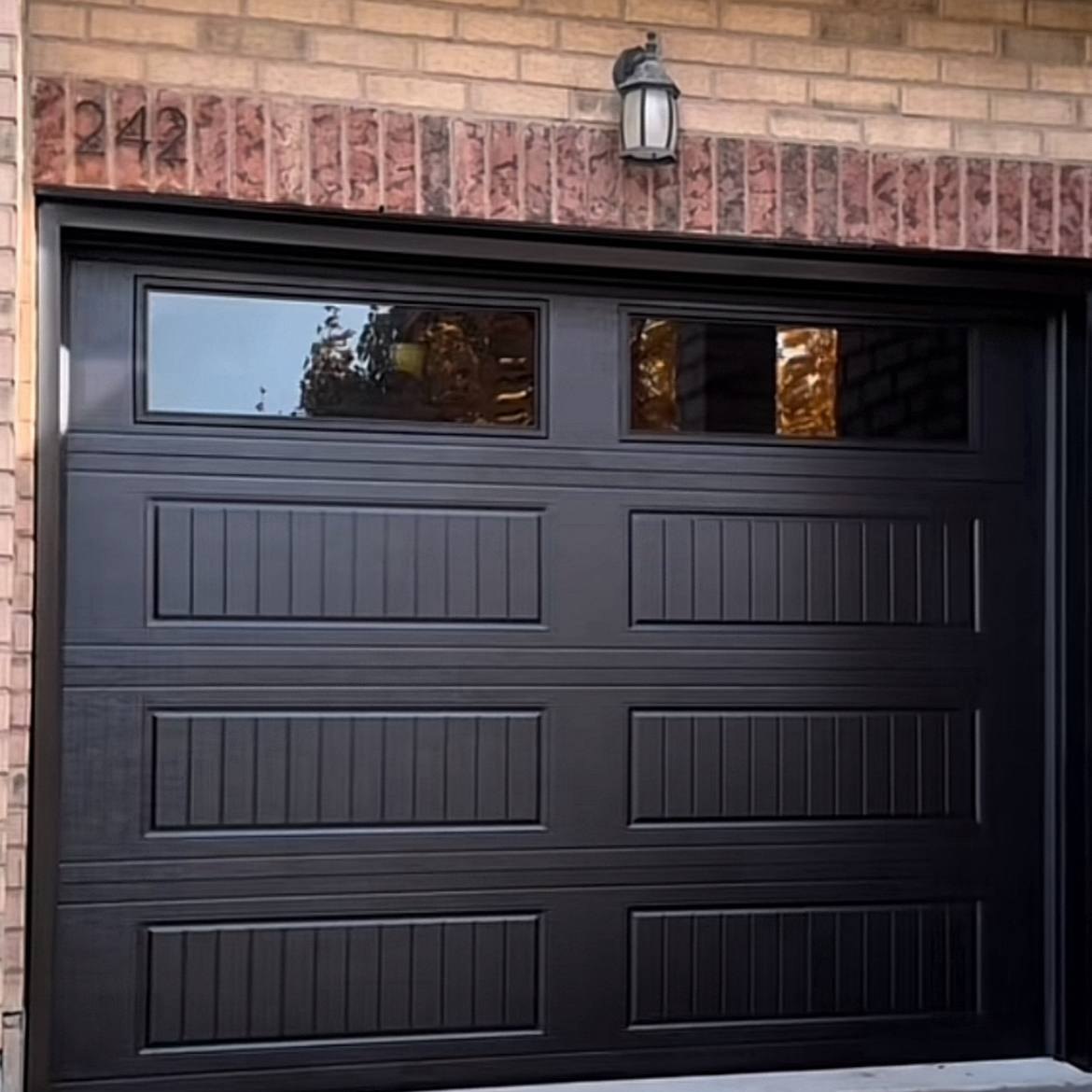 Finished black residential garage door on a brick home in the GTA