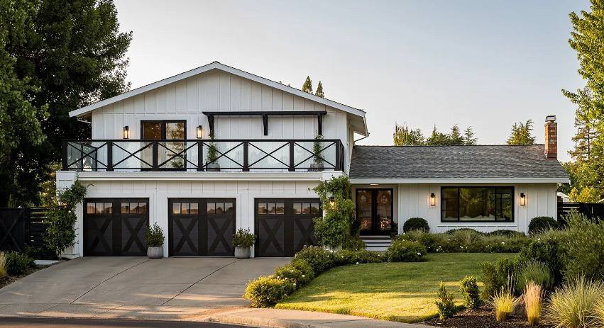 Triple-bay black sectional garage doors at dusk