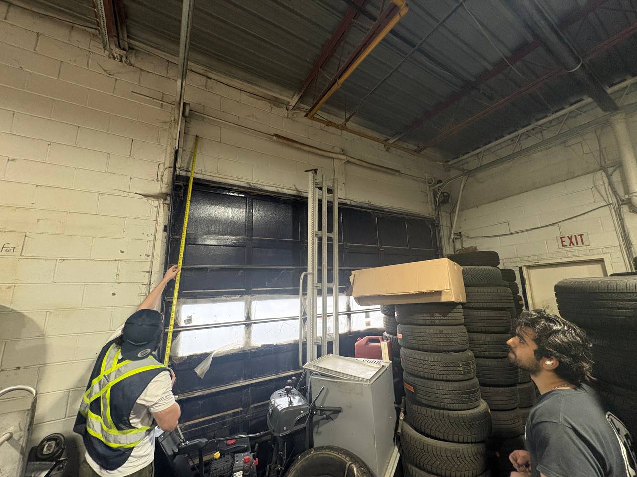 Doorfect technicians servicing a commercial overhead garage door at a GTA business